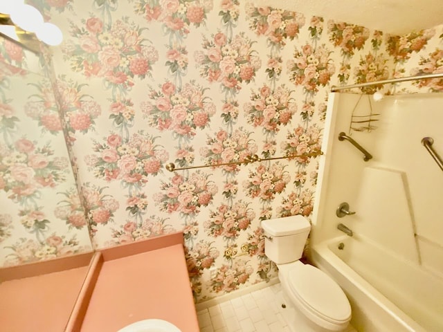 bathroom featuring toilet, baseboards, tub / shower combination, tile patterned floors, and wallpapered walls