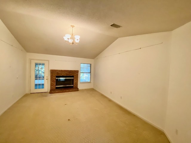 unfurnished living room with visible vents, lofted ceiling, carpet, a fireplace, and a notable chandelier