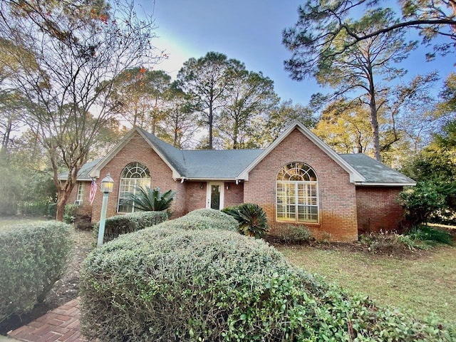 single story home featuring brick siding