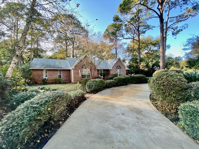 view of front of house with driveway and brick siding