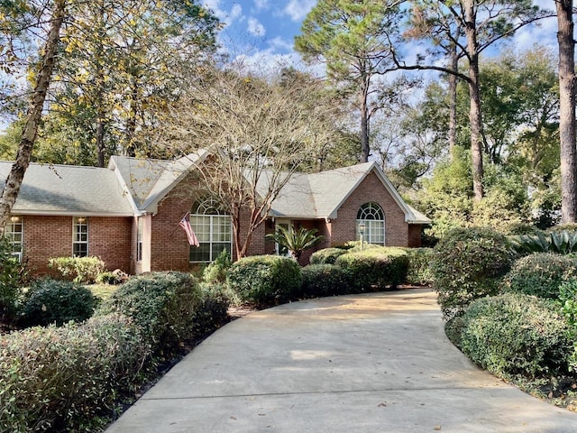 ranch-style house featuring brick siding and driveway