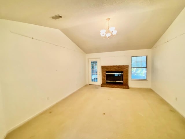 unfurnished living room with carpet floors, a healthy amount of sunlight, vaulted ceiling, and an inviting chandelier