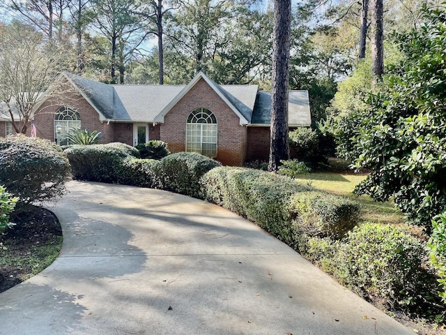 single story home featuring brick siding