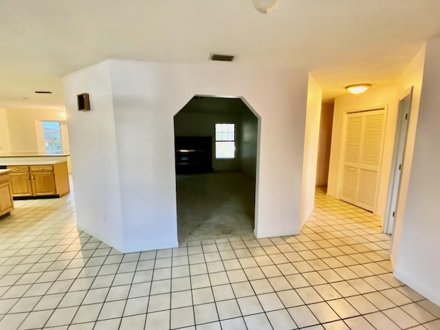 interior space featuring arched walkways, visible vents, and light tile patterned flooring