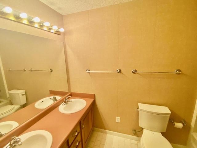 bathroom featuring a sink, a textured ceiling, and toilet