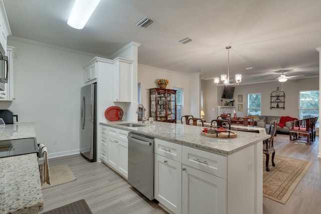 624 W 7th Ave, Tallahassee, FL 32303 - kitchen featuring stainless steel appliances, a peninsula, light wood-type flooring, white cabinetry, and crown molding