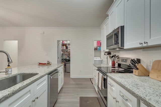 624 W 7th Ave, Tallahassee, FL 32303 - kitchen with appliances with stainless steel finishes, ornamental molding, light wood finished floors, decorative backsplash, and white cabinets