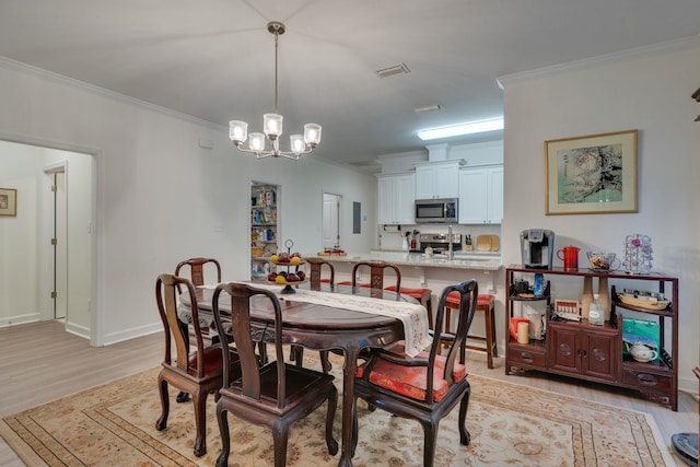 624 W 7th Ave, Tallahassee, FL 32303 - dining area with a chandelier, light wood finished floors, and crown molding