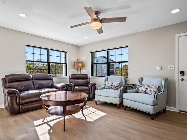 living room featuring a wealth of natural light, ceiling fan, and light wood-type flooring