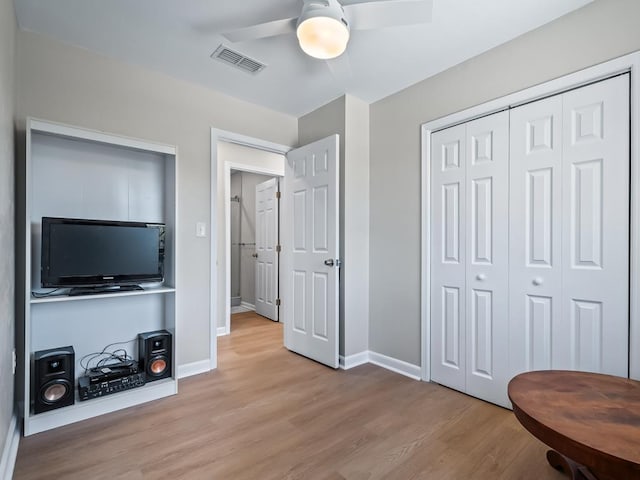 bedroom with ceiling fan, a closet, and light hardwood / wood-style flooring