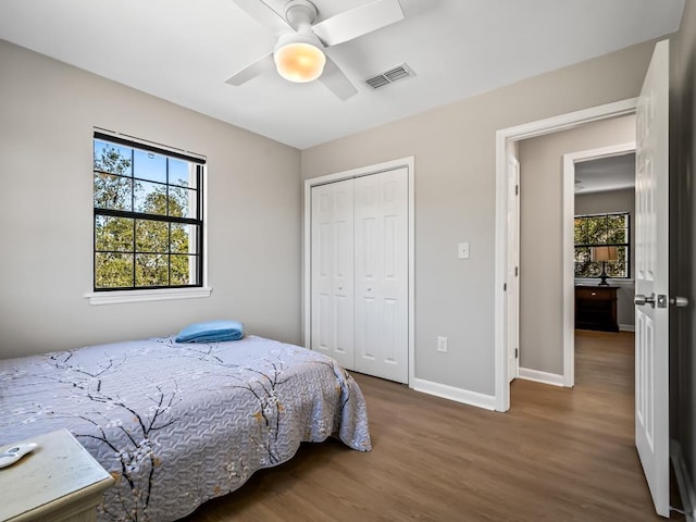 bedroom with hardwood / wood-style floors, a closet, and ceiling fan