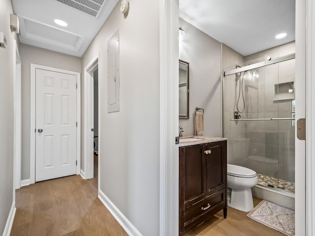 bathroom with vanity, toilet, wood-type flooring, and a shower with door