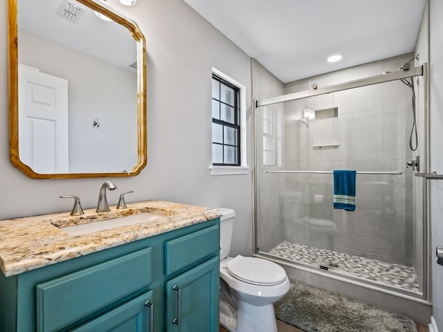 bathroom featuring toilet, vanity, and walk in shower