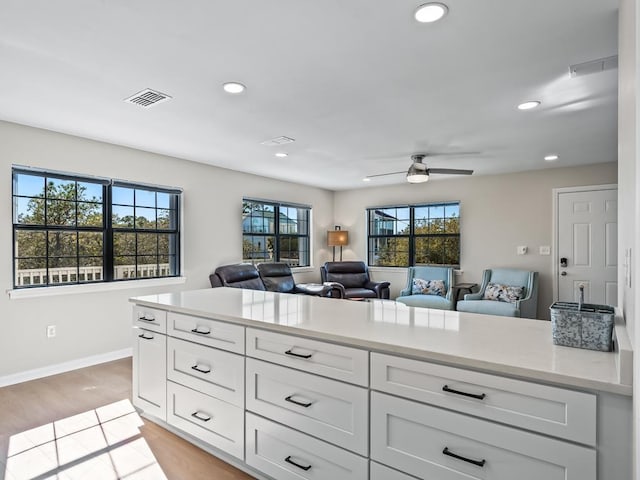 kitchen featuring white cabinetry, ceiling fan, and light wood-type flooring