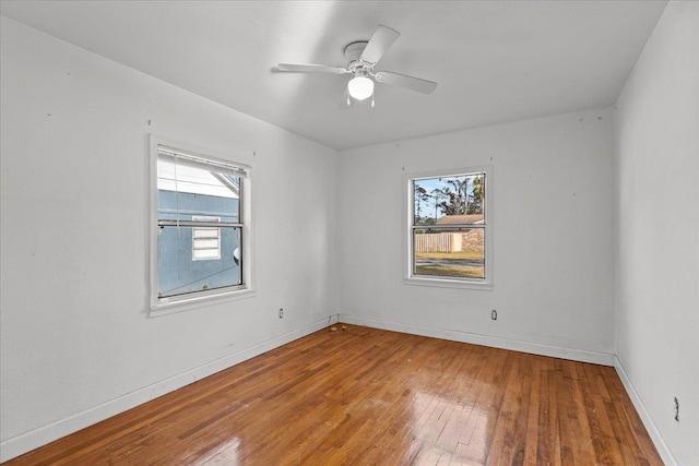 unfurnished room featuring hardwood / wood-style flooring, ceiling fan, and a healthy amount of sunlight