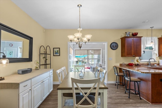 dining space featuring a chandelier, dark wood-type flooring, and sink