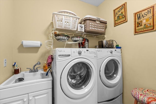 washroom featuring cabinets, sink, and washing machine and clothes dryer