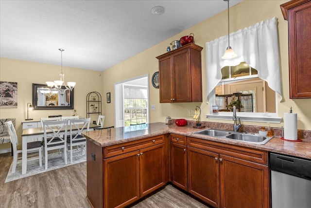 kitchen featuring dishwasher, sink, an inviting chandelier, kitchen peninsula, and light wood-type flooring