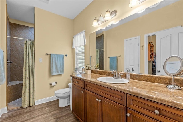 bathroom with a shower with shower curtain, vanity, hardwood / wood-style flooring, and toilet