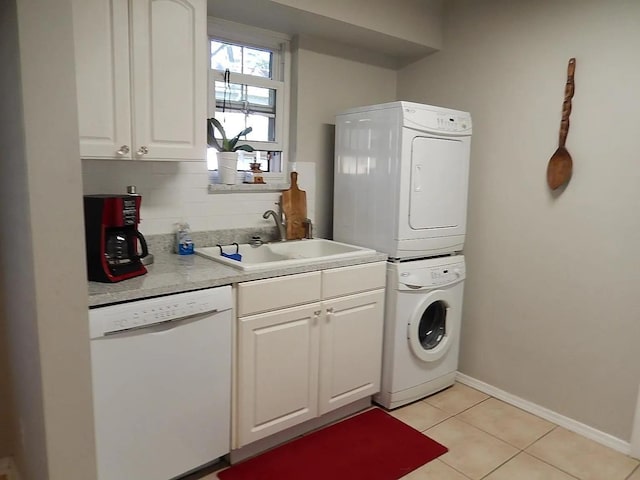 laundry room with light tile patterned flooring, stacked washer / dryer, and sink