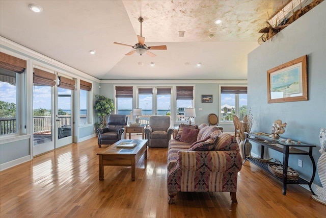 living room with ceiling fan, vaulted ceiling, and light hardwood / wood-style flooring