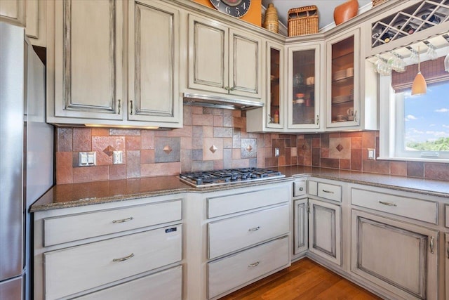 kitchen featuring appliances with stainless steel finishes, backsplash, light hardwood / wood-style flooring, and cream cabinets