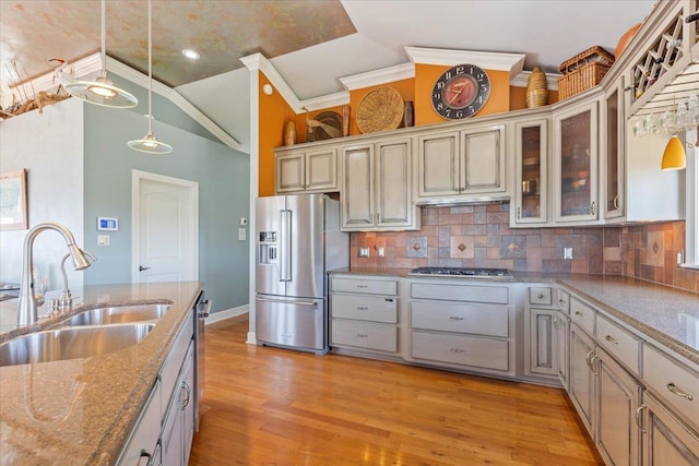 kitchen featuring decorative light fixtures, stainless steel appliances, light hardwood / wood-style flooring, and sink