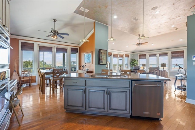 kitchen featuring dark hardwood / wood-style flooring, stainless steel dishwasher, ceiling fan, sink, and pendant lighting