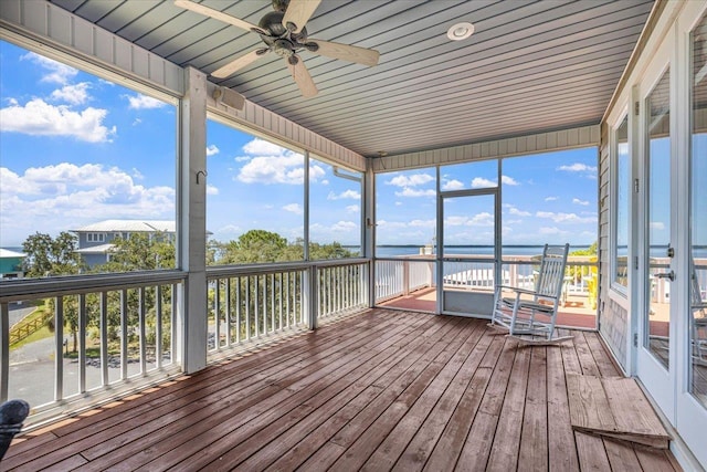 unfurnished sunroom featuring ceiling fan