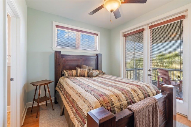 bedroom featuring ceiling fan, light hardwood / wood-style floors, and multiple windows