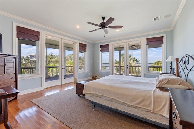 bedroom with access to exterior, french doors, light hardwood / wood-style floors, and multiple windows