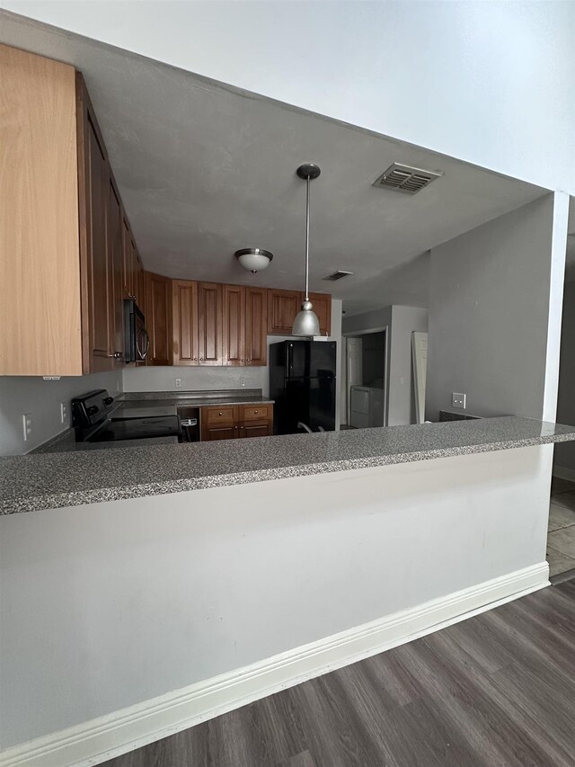 3340 Sugar Berry Way, Tallahassee, FL 32303 - kitchen with black appliances, dark wood-style flooring, a peninsula, hanging light fixtures, and light countertops