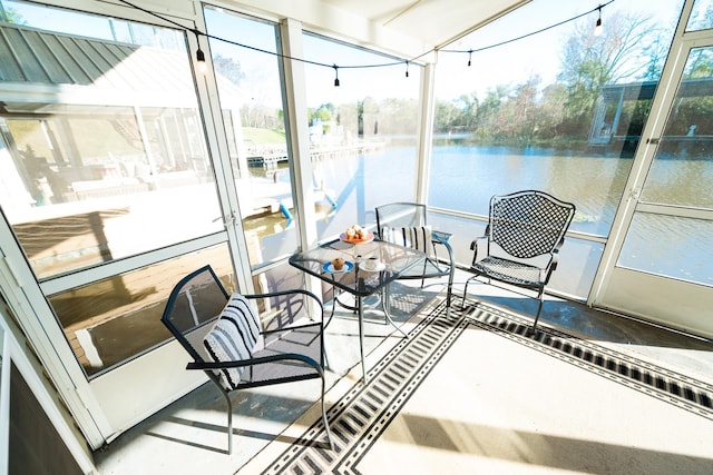 sunroom / solarium featuring a water view