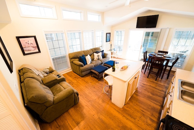 living room featuring ceiling fan, wood-type flooring, and high vaulted ceiling