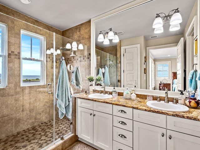 45 Walker Creek Dr, Shell Point, FL 32327 - full bathroom with a stall shower, double vanity, and a chandelier