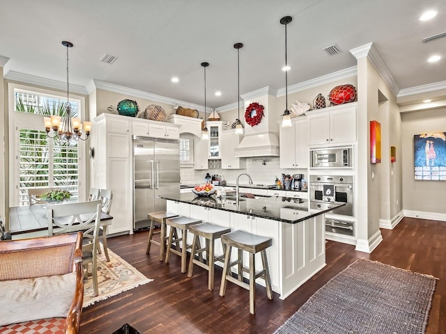 45 Walker Creek Dr, Shell Point, FL 32327 - kitchen featuring built in appliances, ornamental molding, a chandelier, dark wood-type flooring, and decorative backsplash