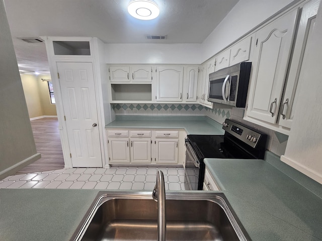 kitchen featuring white cabinetry, appliances with stainless steel finishes, sink, and decorative backsplash