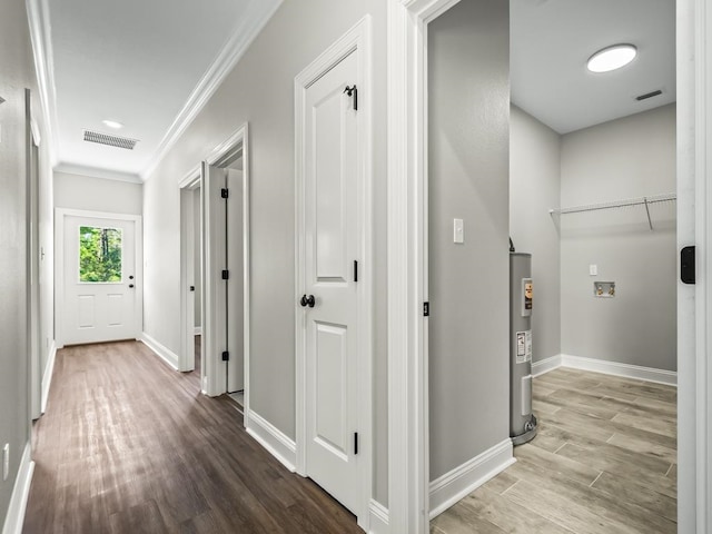 corridor featuring electric water heater, wood-type flooring, and ornamental molding