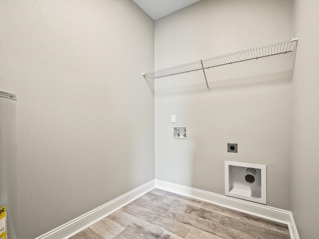 washroom featuring light wood-type flooring, washer hookup, and hookup for an electric dryer