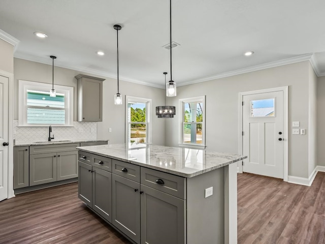 kitchen with gray cabinets, a kitchen island, decorative light fixtures, and dark hardwood / wood-style floors