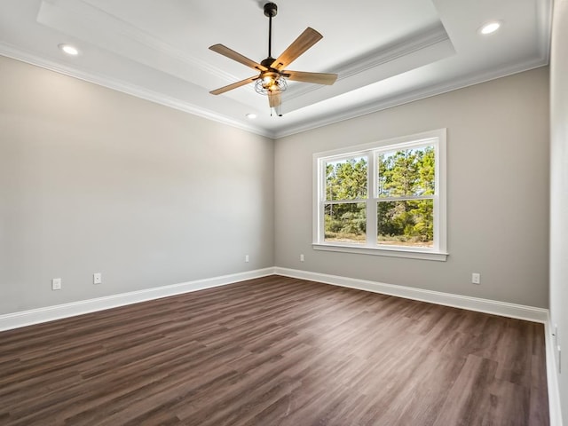 spare room with dark hardwood / wood-style flooring, a raised ceiling, ceiling fan, and crown molding