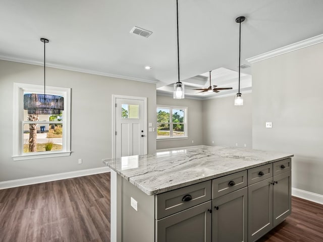 kitchen with light stone counters, crown molding, gray cabinets, pendant lighting, and dark wood-type flooring