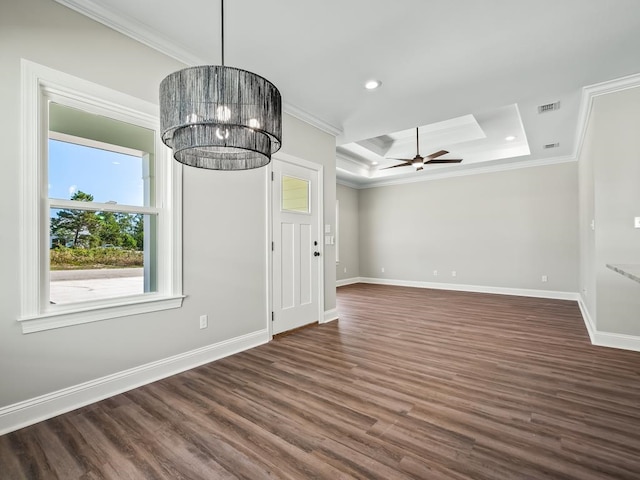 interior space featuring dark wood-type flooring, ceiling fan with notable chandelier, crown molding, and a tray ceiling