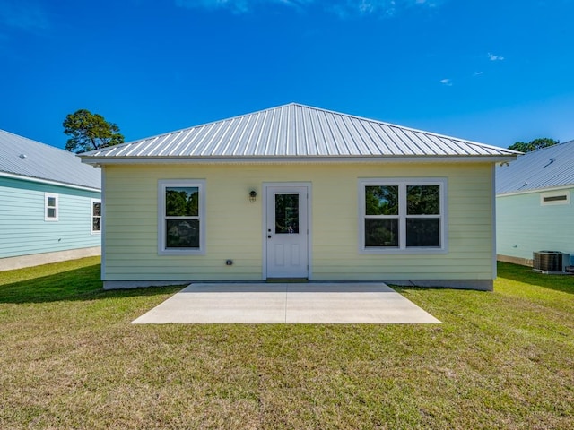 rear view of house with a lawn, cooling unit, and a patio area