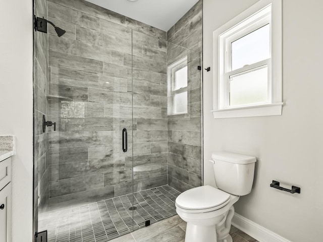 bathroom featuring an enclosed shower, vanity, and toilet