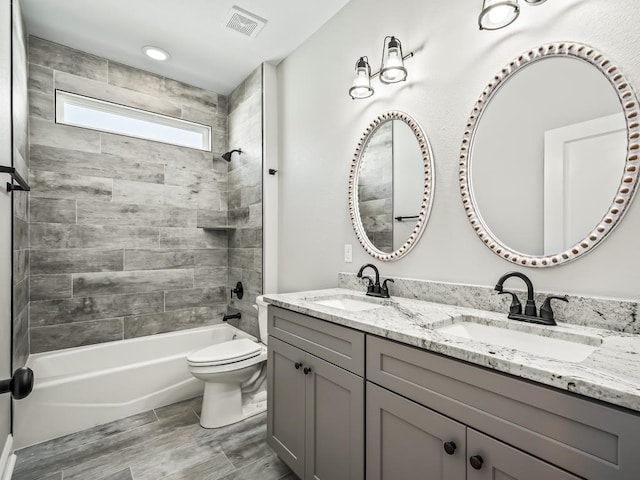 full bathroom with toilet, vanity, tiled shower / bath, and wood-type flooring