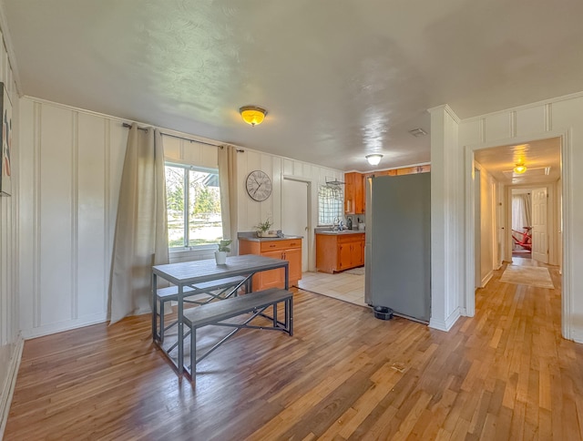 dining space featuring a decorative wall and light wood finished floors