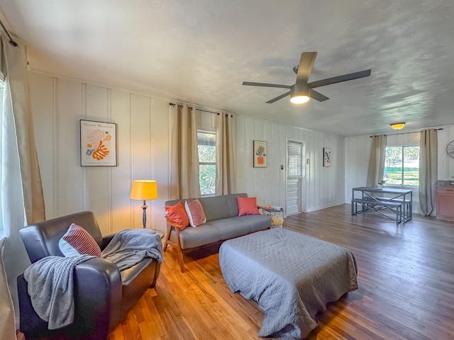 living room with a ceiling fan and light wood-style flooring