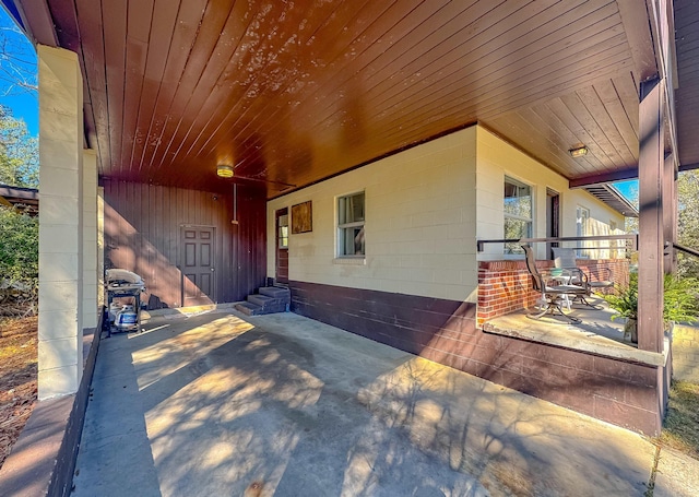 property entrance featuring concrete block siding and a patio