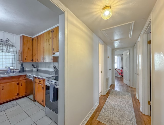 kitchen with visible vents, appliances with stainless steel finishes, brown cabinets, light countertops, and under cabinet range hood